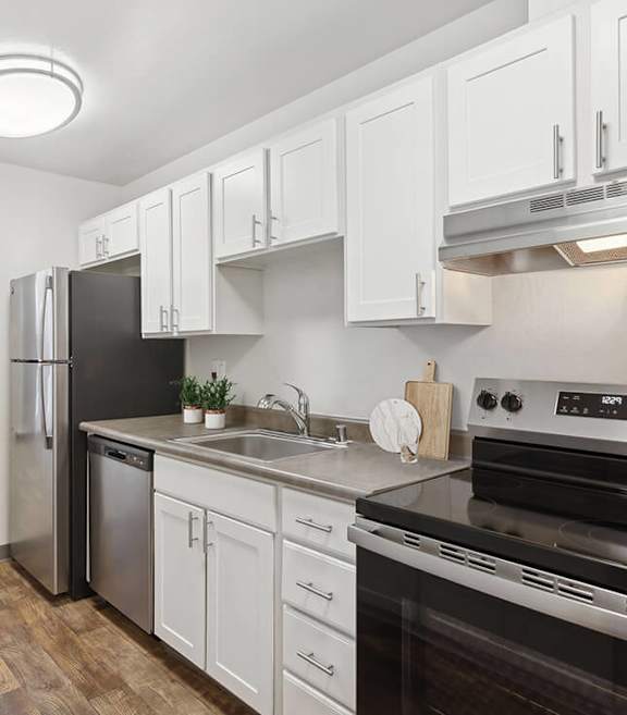Model Kitchen with White Cabinets and Wood-Style Flooring at Los Gatos Landing Apartments located in San Jose, CA-SMLAM.