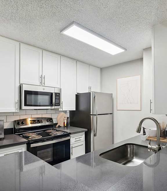 Model Kitchen with White Cabinets and Wood-Style Flooring at Madison Park Apartments located in Anaheim, CA-SMLAM.