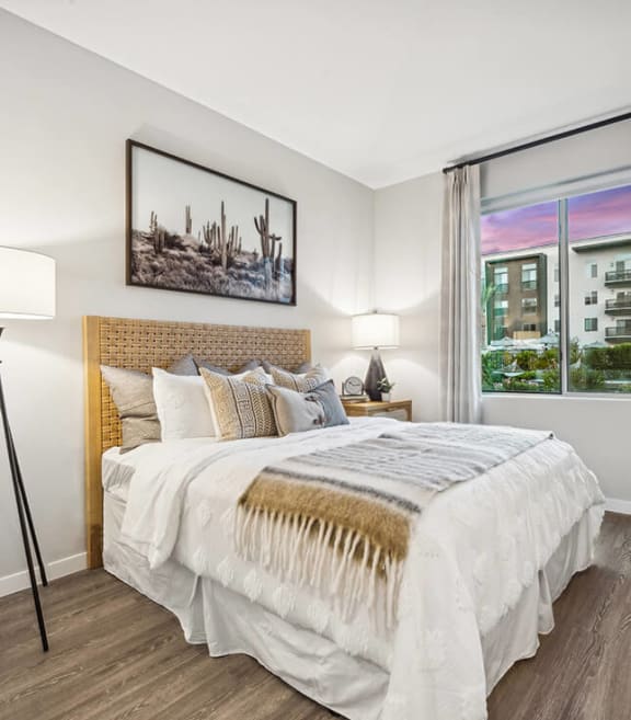 Model Bedroom with Wood-Style Flooring and Window View at Glen 91 Apartments located in Glendale, AZ-SMLAM.