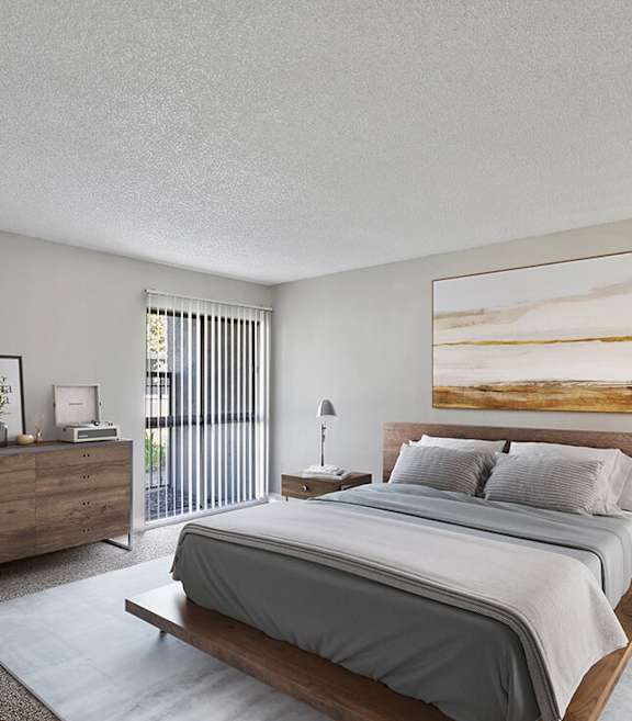 Model Bedroom with Carpet and Patio Accessibility at Madison Park Apartments located in Anaheim, CA-SMLAM.