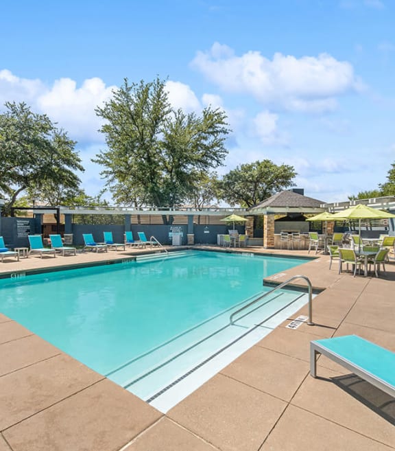 Community Swimming Pool with Pool Furniture at Allure North Dallas Apartments in Dallas, TX-SMLAM.