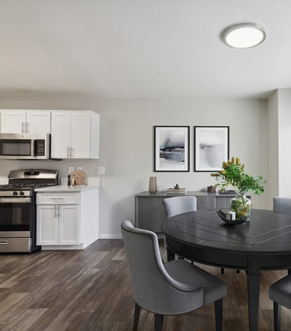 Model Dining Room with Wood-Style Flooring and View of Kitchen at Loma Vista Apartments in Las Vegas, NV-SMLAM.