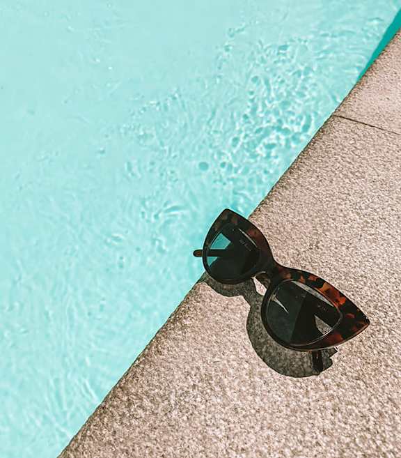 Stock Photo of Sunglasses by a Swimming Pool-SMLAM.