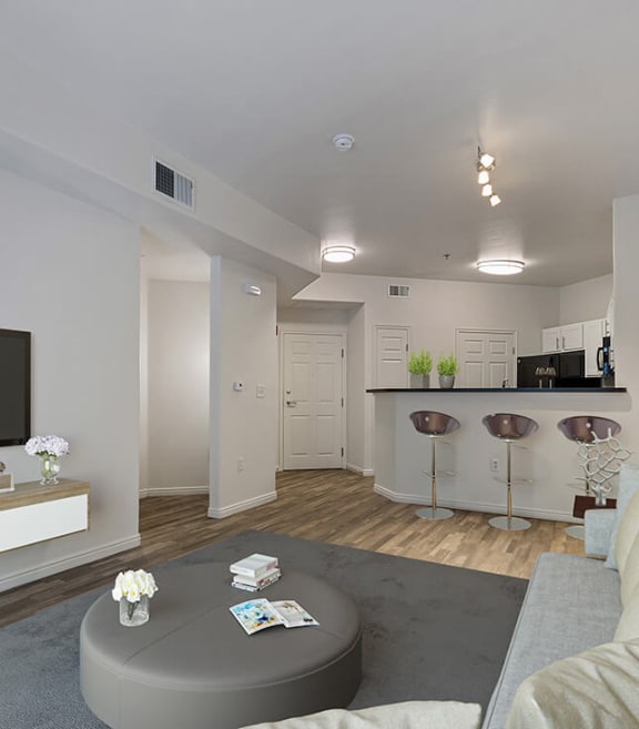 Model Living Room with Wood-Style Flooring and View of Kitchen at Altitude on Fifth Apartments in Salt Lake City, UT-SMLAM.