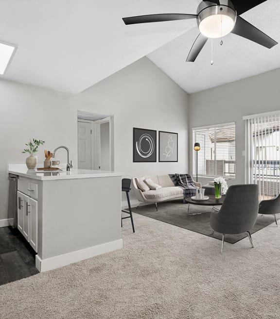Model Living Room with Carpet and View of Kitchen at Crystal Creek Apartments located in Phoenix, AZ-SMLAM.