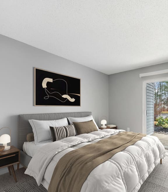 Model Bedroom with Carpet and Patio Accessibility at Commons at Haynes Farm Apartments in Shrewsbury, MA-SMLAM.