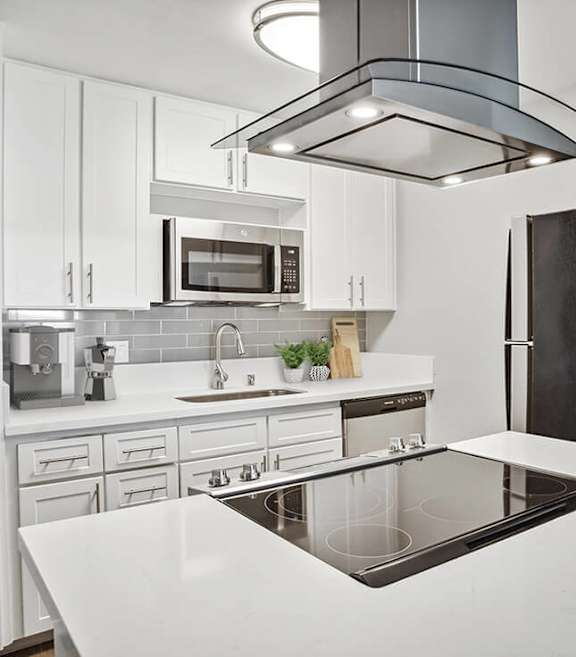 Model Kitchen with White Cabinets and Wood-Style Flooring at Cove La Mesa Apartments located in La Mesa, CA-SMLAM.