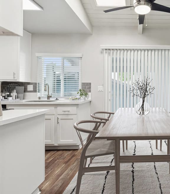 Model Dining Room and Kitchen Area with Wood-Style Flooring and Patio Accessibility at Colonnade at Fletcher Hills Apartments in El Cajon, CA-SMLAM.