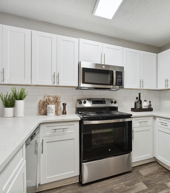 Model Kitchen with Wood-Style Flooring and White Cabinets at Retreat at Stonecrest Apartments located in Lithonia, GA-SMLAM.