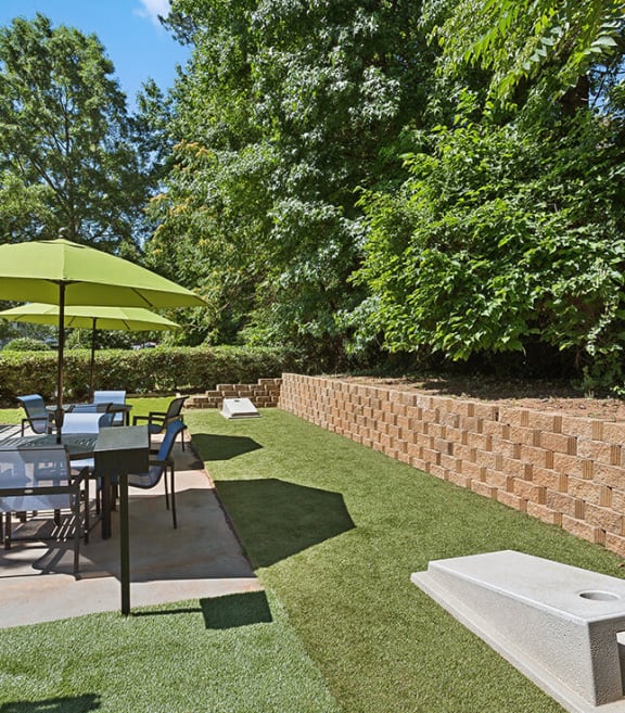 Outdoor Picnic Area with Lounge Furniture and Corn Hole Sets at Retreat at Stonecrest Apartments located in Lithonia, GA-SMLAM.