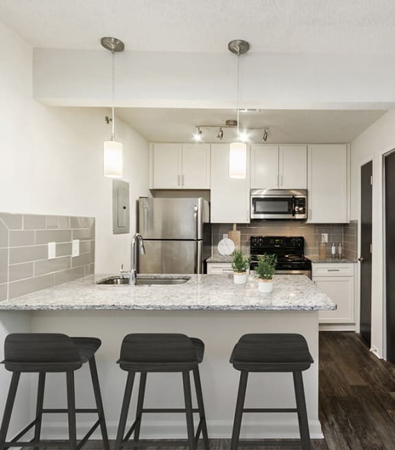 Model Kitchen with White Cabinets and Wood-Style Flooring at Grandstand Apartments in Marietta, GA-SMLAM.