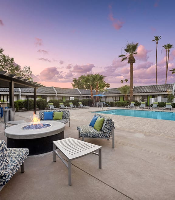 Outdoor Fire Pit Area and Swimming Pool with Lounge Furniture at Arcadia on 49th Apartments located in Phoenix, AZ-SMLAM.