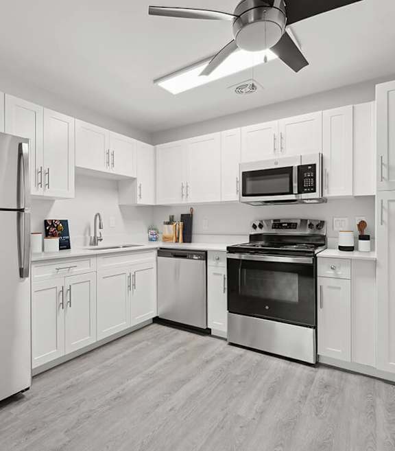 Model Kitchen with White Cabinets and Wood-Style Flooring at The Grove at Walnut Creek Apartments located in Walnut Creek, CA-SMLAM.
