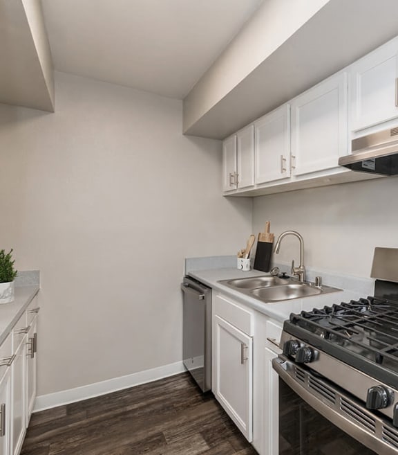 Model Kitchen with White Cabinets and Wood-Style Flooring at Indigo Park Apartments in Albuquerque, NM-SMLAM.
