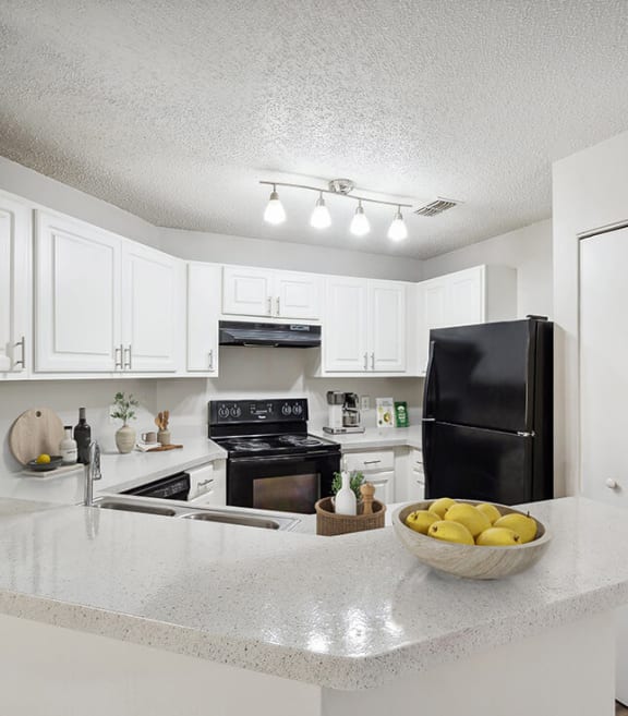 Model Kitchen with White Cabinets and Wood-Style Flooring at Westland Park Apartments in Jacksonville, FL-SMLAM.