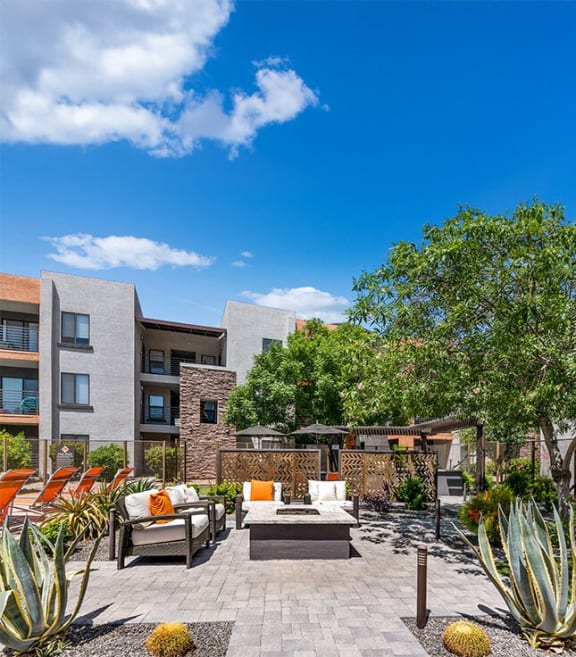 a patio with chairs and a table in a courtyard
