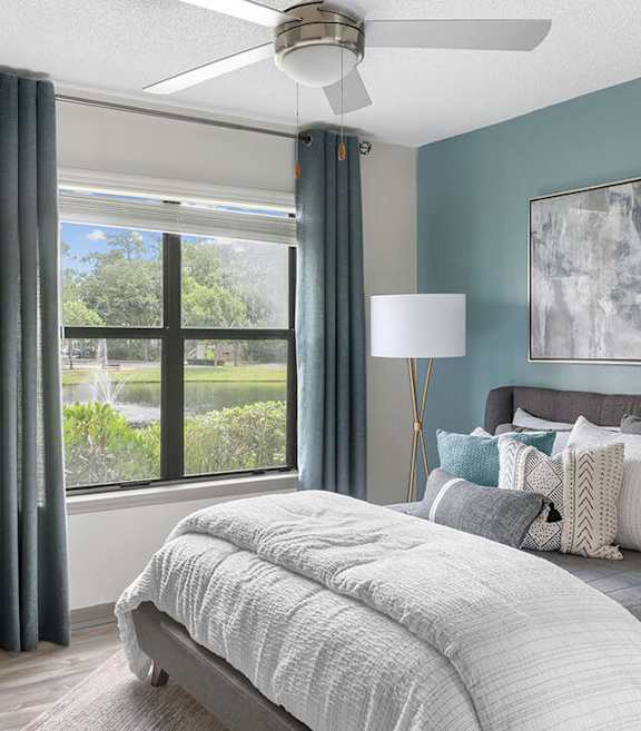 Model Bedroom with Wood-Style Flooring and Window View at Mirage on Kernan Apartments located in Jacksonville, FL-SMLAM.