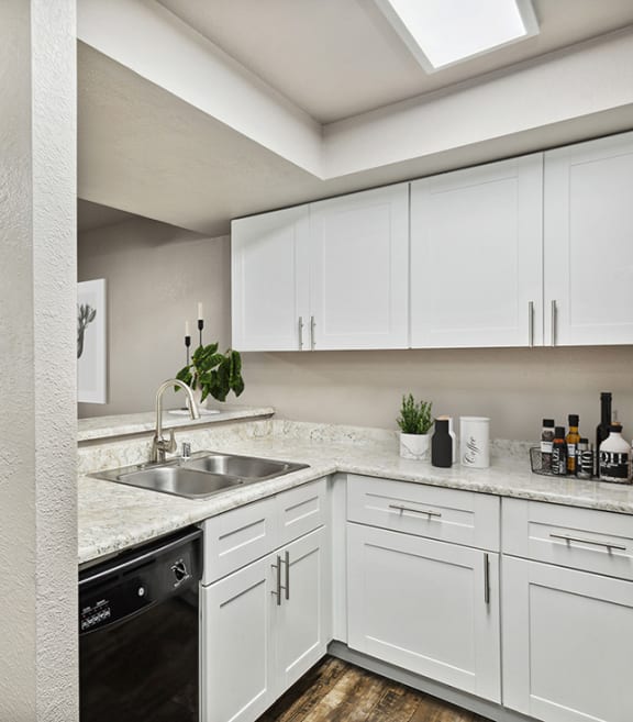 Model Kitchen with White Cabinets and Wood-Style Flooring at Creek at 2645 Apartments located in Sacramento, CA-SMLAM.