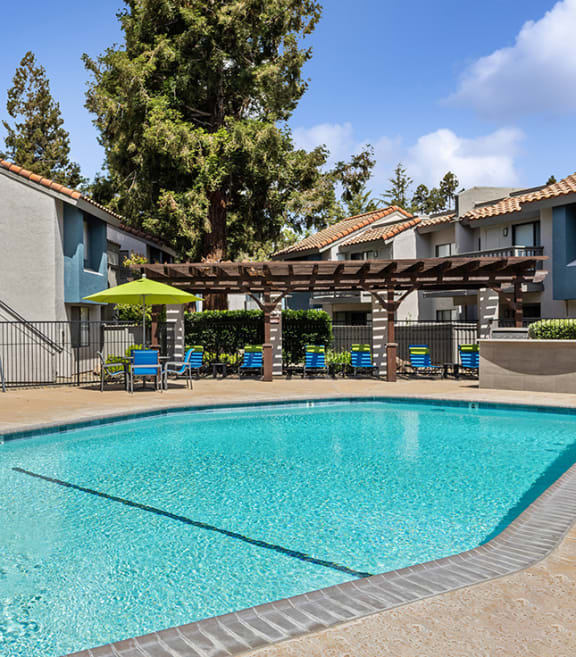 Community Swimming Pool with Pool Furniture at Creek at 2645 Apartments located in Sacramento, CA-SMLAM.