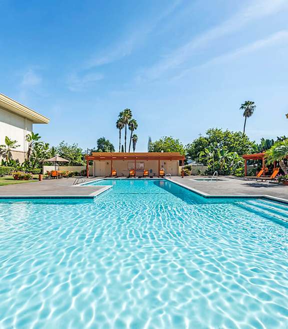 Community Swimming Pool with Pool Furniture at Crystal View Apartments located in Garden Grove, CA.