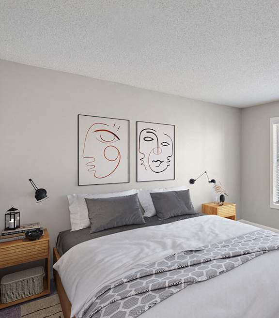 East Charlotte, NC, Affordable Apartments Near Albemarle Road Elementary - Woodland Estates - A Bedroom With A Large Bed, Wall Art, Wood Nightstands With Lamps, A Large Window, And A Potted Plant.