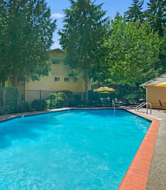 Woman with a straw sunhat sitting with her legs in the pool