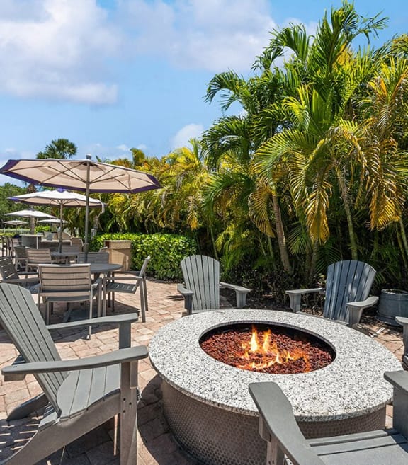 Community sundeck with firepit lounge at Waverley Place Apartments in Naples, Florida