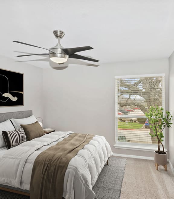 Model Bedroom with Carpet and Window View at Woodcreek Apartments located in Arlington, TX-SMLAM.