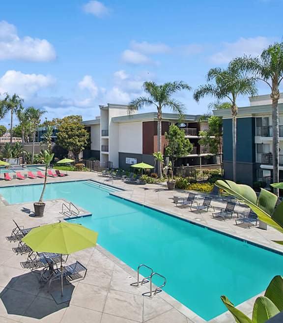 Community Swimming Pool with Pool Furniture at Madison Park Apartments located in Anaheim.