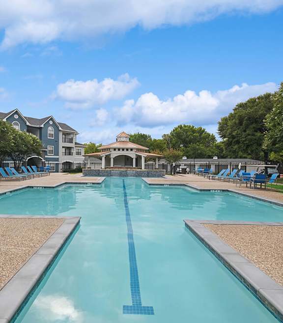 Community Swimming Pool with Pool Furniture at Hidden Creek Apartments located in Lewisville, TX.