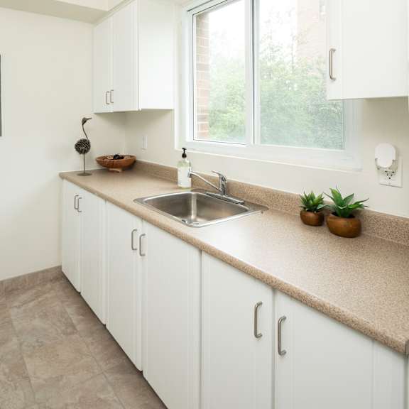 A small kitchen with a washing machine and a sink.