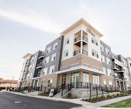 a new apartment building with balconies and stairs on a sidewalk