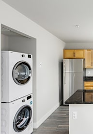 A modern kitchen with a black countertop and wooden cabinets.
