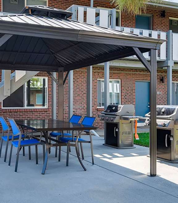 A patio with a table and chairs under a roof.