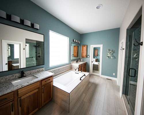 A bathroom with a white tub and wooden cabinets.