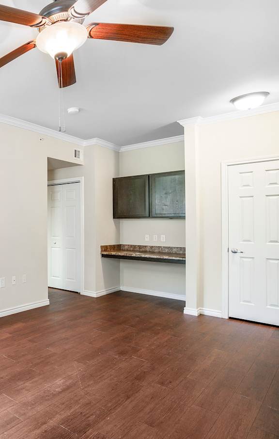 A large open living room with a kitchen in the background.