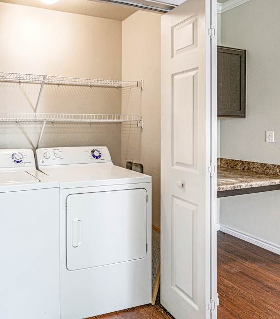 A white washer and dryer are sitting in a small laundry room.