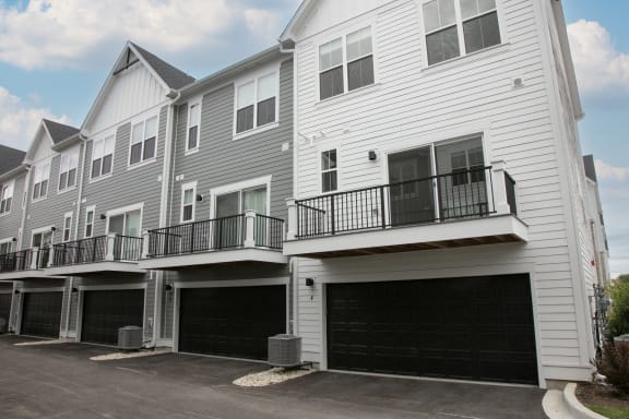 the front of a white house with two garages at Enclave Crystal Lake Townhomes and Apartments, Crystal Lake, Illinois