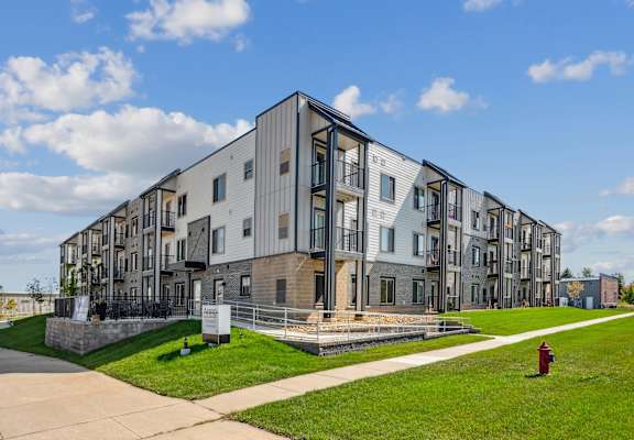 A modern apartment complex with a red fire hydrant in front.