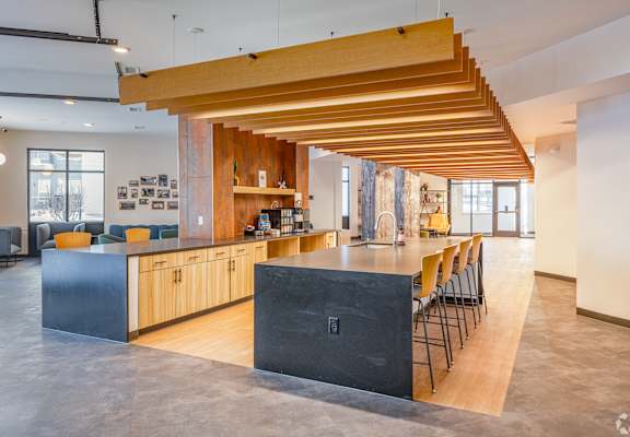 A modern kitchen with wooden beams and a black counter.