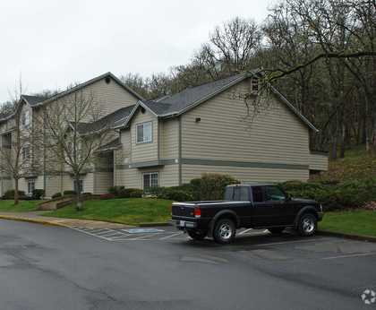 A black truck is parked on the right side of a street.