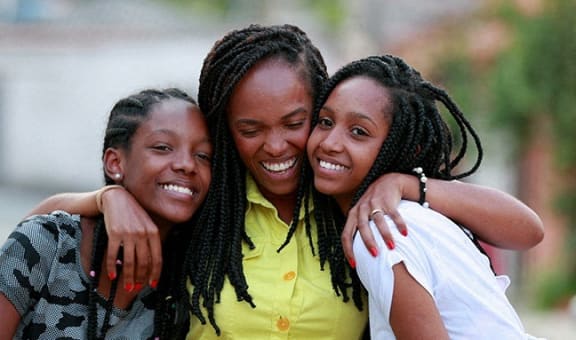 a group of young girls hugging each other and smiling