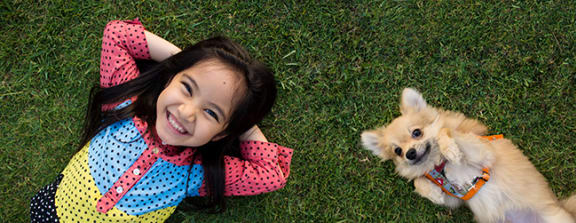 Child and dog in grass at Crocker Village – Single Family Homes, Sacramento California