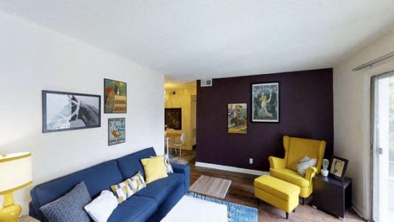a living room with a blue couch and yellow chairs at Viceroy Apartments, North Carolina, 27707