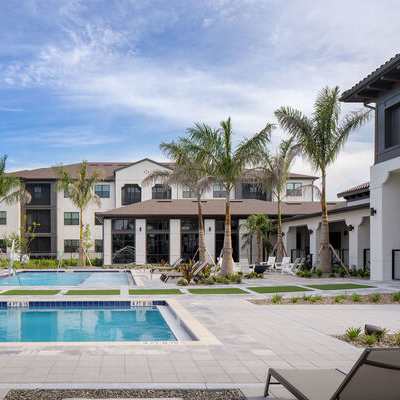 A swimming pool in front of a row of houses.