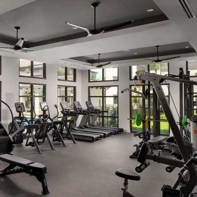 A gym with a variety of equipment including treadmills, stationary bikes, and weight machines.