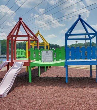 a playground with a slide and swings at a park