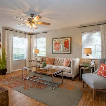 a living room filled with furniture and a ceiling fan