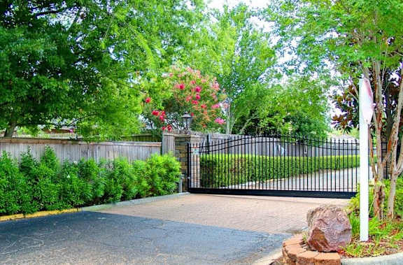 A brick wall with a metal railing and a tree in front of a building.