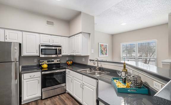A kitchen with white cabinets and a black stove top.